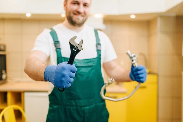 plumber-in-uniform-holds-wrench